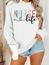 Nurse Life Pastel Letters Sweatshirt in White, front view on a model holding a coffee cup