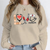 Nurse Love #Nurselife Graphic Sweatshirt in Khaki, front view on a model, hands in jean pockets