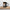 Don't Tell Me How to Do My Job black glossy mug, 15 oz, standing on a wooden board with the placard facing the camera and the handle at right